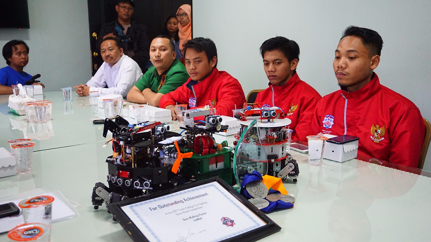 Ketiga mahasiswa yang mengikuti lomba (jaket merah) saat mempresentasikan teknis memfungsikan robot